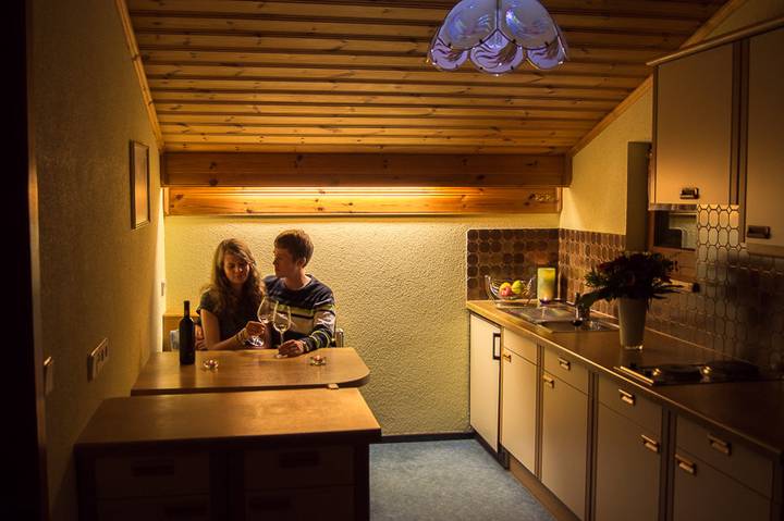 Wohnküche mit Esstisch und Holzdecke