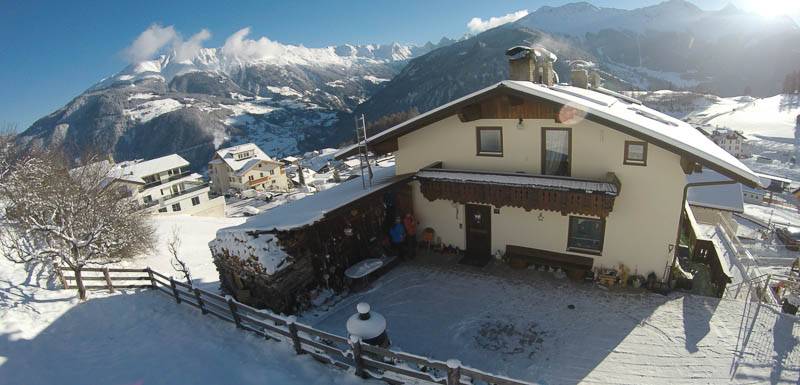 Das Haus der Familie Wolf im Schnee vor den Tiroler Bergen